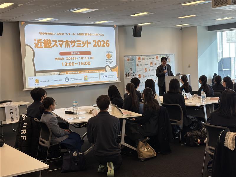 サミット会場で1人の男性が演台に立ち、生徒たちの前で話をしている様子