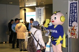 電子申請体験コーナーの前にいるデンパ君画像