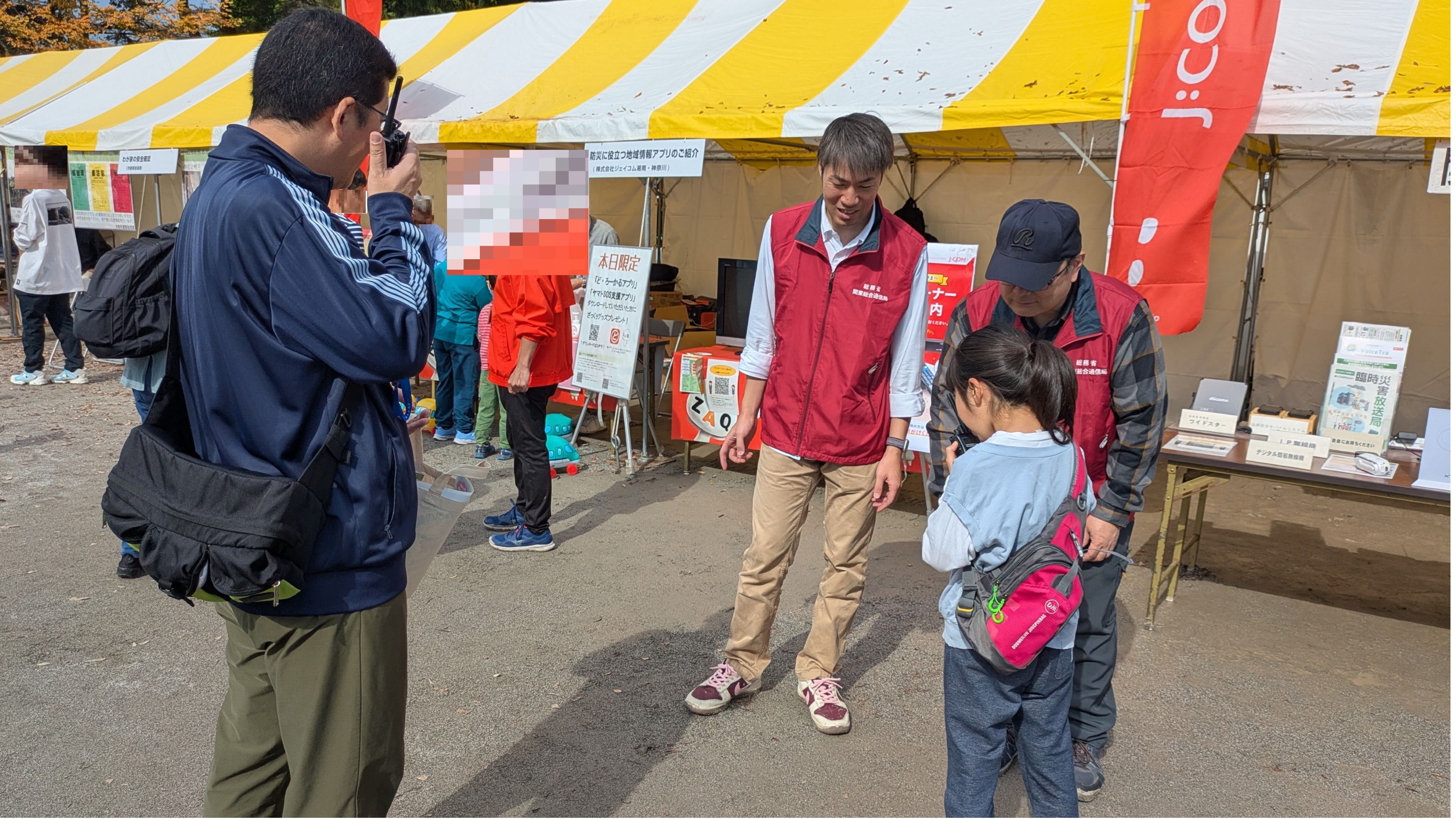 簡易無線の操作・通信体験中の子供連れの来場者